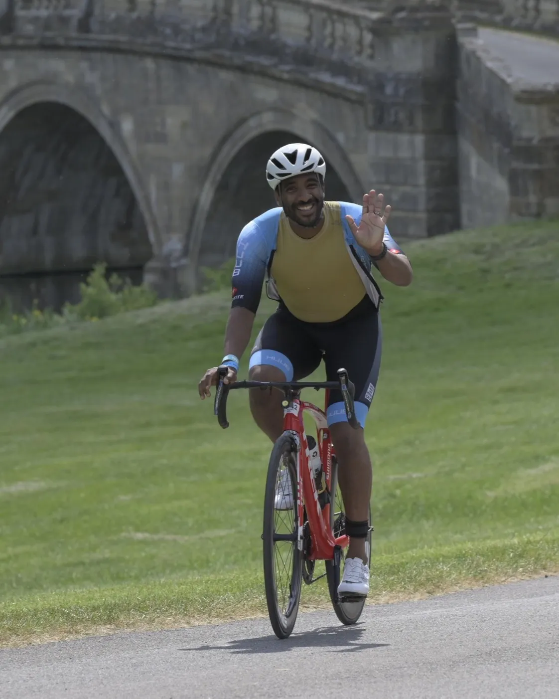 Abraham Spring smiling and waving on the Blenheim Palace cycle course
